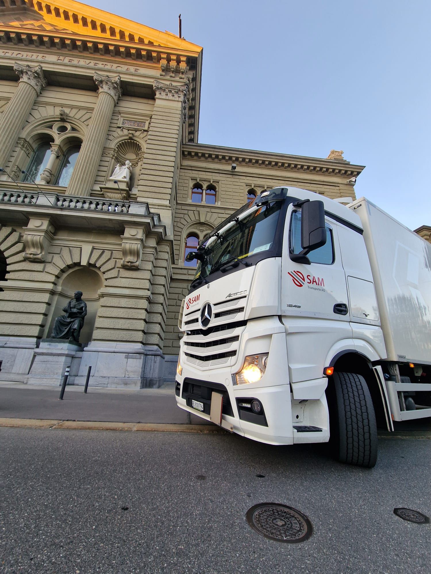 SAM Transporte AG LKW vor historischem Gebäude